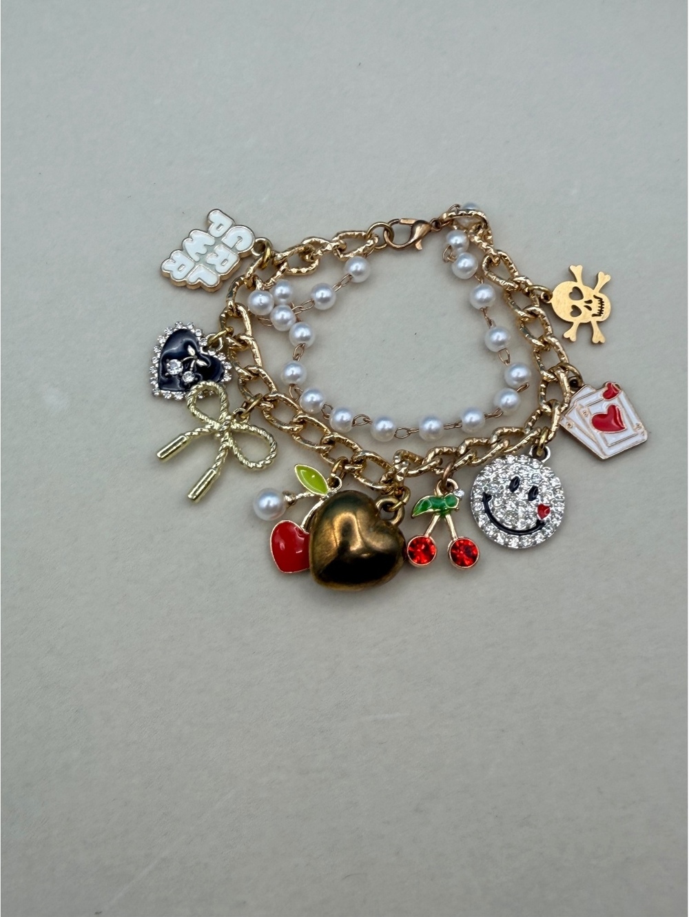 Gold tone charm bracelet with pearls